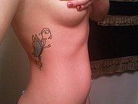 Blondes M�dchen mit Nippelpiercing und Tattoo